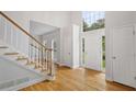 Bright foyer with gleaming hardwood floors, staircase, and a large picture window at 3014 Volland Grove Trail, Lawrenceville, GA 30043