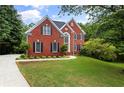 Beautiful red brick home featuring a well-manicured lawn and inviting curb appeal at 3014 Volland Grove Trail, Lawrenceville, GA 30043