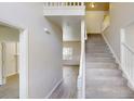Bright entryway with light gray wood floors, white walls, and a carpeted staircase leading to the second floor at 4912 Lightwood Nw Ct, Acworth, GA 30102