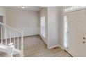 Open entryway featuring natural light, stairs with white railing, and neutral walls with wood trim at 4912 Lightwood Nw Ct, Acworth, GA 30102