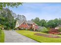 Attractive brick home on a well-maintained lot with a long driveway and plenty of greenery at 9545 Kingston Crossing Cir, Alpharetta, GA 30022