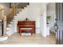Bright foyer featuring a hardwood floor, staircase with iron railings, and a vintage piano at 9545 Kingston Crossing Cir, Alpharetta, GA 30022