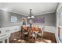 Formal dining room with hardwood floors, gray walls, and elegant chandelier at 11950 Wildwood Springs Dr, Roswell, GA 30075