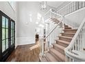 Grand foyer with hardwood floors, high ceilings, and a staircase with white railings at 11950 Wildwood Springs Dr, Roswell, GA 30075