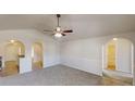 Open-concept living room with arched doorways, and neutral walls and carpet offers a bright and inviting living space at 4954 River Overlook Way, Lithonia, GA 30038