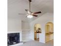 Bright living room with vaulted ceilings, a ceiling fan, and arched entryways offering a seamless transition to the kitchen at 4954 River Overlook Way, Lithonia, GA 30038