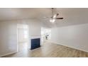 Bright living room featuring light wood floors, fireplace, and view into the kitchen at 6614 Biscayne Blvd, Rex, GA 30273