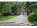 Brick home with attached garage, driveway, and well-maintained lawn with mature trees at 1243 Williamswood Pointe, Decatur, GA 30033