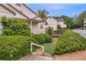 View of condo with beige exterior, manicured bushes, and staircase leading to front door at 203 Bridge Se Ln, Smyrna, GA 30082