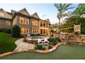 Backyard featuring an outdoor hot tub, patio with stone fireplace and seating at 341 Carl Sanders Dr, Acworth, GA 30101