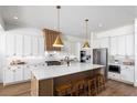 Bright kitchen featuring a large center island with seating, stainless steel appliances, and white cabinets at 7460 Trotting Trl, Cumming, GA 30040