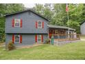 View of a two-story home with gray siding, red shutters, and a well-maintained lawn at 1341 Timbercrest Ct, Lawrenceville, GA 30045