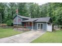 A charming home with gray siding, a front porch, and a well-manicured lawn at 1341 Timbercrest Ct, Lawrenceville, GA 30045