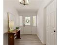 Bright entryway features a white front door with sidelights, light wood flooring, and decorative accents at 340 Monivea Ln, Roswell, GA 30075