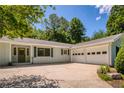 Front exterior with a three-car garage, complemented by a well-maintained driveway and a welcoming entrance at 340 Monivea Ln, Roswell, GA 30075