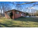 Angle view of the brick home's exterior, showing the carport and the neat landscaping at 7427 Hollis Rd, Douglasville, GA 30135