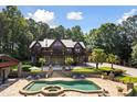 Beautiful exterior of a log cabin style home with a pool and a stone patio at 4095 E Highway 166 Hwy, Carrollton, GA 30116