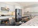 Modern kitchen with sleek black countertops, white cabinets, and stainless steel appliances at 5360 Northwater Way, Duluth, GA 30097