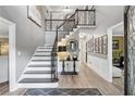 Elegant foyer with staircase, featuring gray walls, white trim, and wood floors at 910 Kings Arms Way, Alpharetta, GA 30022