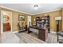 A stylish office space featuring warm yellow walls, elegant furnishings and luxury vinyl plank flooring at 910 Kings Arms Way, Alpharetta, GA 30022