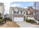 Charming exterior featuring a well-manicured lawn and attached two-car garage at 1212 Lake Point Way, Suwanee, GA 30024