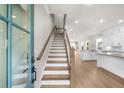 Bright entryway with hardwood floors, a staircase with wooden banister, and a view of the open kitchen and living area at 219 Phillips Ln, Alpharetta, GA 30009