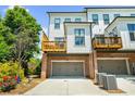 View of two-story townhomes showcasing a garage and a wooden deck overlooking a driveway at 219 Phillips Ln, Alpharetta, GA 30009