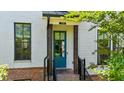 Inviting front entrance with a vibrant blue door, brick accents, and stylish black railings and natural wood posts at 219 Phillips Ln, Alpharetta, GA 30009