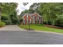 Lovely two-story brick home with a well-maintained lawn and mature trees at 5010 Bonnie Way, Roswell, GA 30075