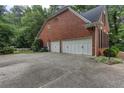 Spacious three-car garage with a large driveway and brick exterior at 5010 Bonnie Way, Roswell, GA 30075