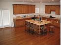 Spacious eat-in kitchen with wood cabinets, matching island, and hardwood floors at 947 Simonton View Ln, Lawrenceville, GA 30045