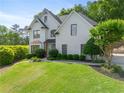 Beautifully landscaped lawn with mature trees, complemented by a painted brick exterior and black trim at 103 Caracas Dr, Woodstock, GA 30188