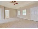 Bright bedroom with carpet flooring, tray ceiling, and a private en-suite bathroom at 126 Usher Ln, Covington, GA 30016