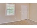 Bright room with carpet, a window letting in natural light, and a white door providing access at 126 Usher Ln, Covington, GA 30016
