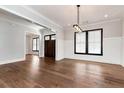 Elegant dining room with modern lighting, wainscoting detail, and hardwood floors at 320 Dodd Ln, Alpharetta, GA 30005