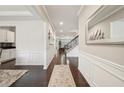 Elegant hallway showcasing dark hardwood floors, white wainscoting, and a view of the staircase at 130 W Pier Way, Fayetteville, GA 30214