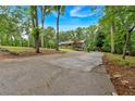 Long driveway leading to a charming home, surrounded by mature trees and lush landscaping at 305 Devilla Trce, Fayetteville, GA 30214