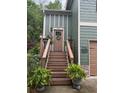 Inviting front entrance featuring a wooden staircase, decorative plants, and a stylish door with a wreath at 313 India Ln, Canton, GA 30114