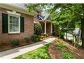 Close-up of a lovely brick home with lush landscaping and a charming walkway leading to the front door at 4561 Jenkins Way, Douglasville, GA 30135