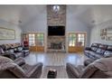 Open living room with high ceilings, stone fireplace, wood floors, and comfortable leather seating at 540 Benton Rd, Covington, GA 30014