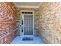 Close-up of a stylish front door with brick and stone accents plus a welcome mat at 9872 Cameron Parc Cir, Johns Creek, GA 30022