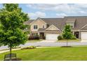 Well-maintained townhome with a two-car garage, beautiful landscaping, and a welcoming front yard at 2141 Slick Stone Dr, Snellville, GA 30078