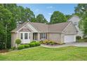 Inviting brick home with lush green lawn, mature trees, and attached two-car garage at 3463 Dunbar Ln, Suwanee, GA 30024