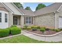 Close-up view of brick facade, tidy landscaping, and pathway to front door at 3463 Dunbar Ln, Suwanee, GA 30024