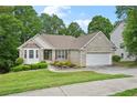 Attractive one-story home featuring brick facade, well-manicured lawn, and an attached garage at 3463 Dunbar Ln, Suwanee, GA 30024
