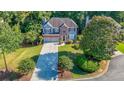 Well-maintained two-story home showcasing lush landscaping, a long driveway, and blue and brick facade at 111 Springshade Ln, Canton, GA 30114