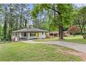 A cozy ranch-style home with a long driveway, carport, and beautiful yard surrounded by trees at 2148 Meador Se Ave, Atlanta, GA 30315