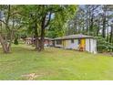 A charming one-story home with a well-manicured lawn and inviting yellow door in a wooded setting at 2148 Meador Se Ave, Atlanta, GA 30315