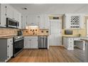 Well-lit kitchen featuring white cabinets, stainless steel appliances and granite countertops at 3171 Davis Rd, Marietta, GA 30062