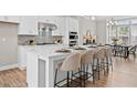 Elegant kitchen with a central island, seating, quartz countertops, stainless steel appliances, and modern backsplash at 964 Catamaran Ct, Alpharetta, GA 30005